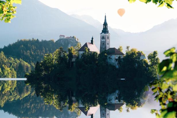 Der Bleder See mit der Kirche auf der Insel und der Burg im Hintergrund.