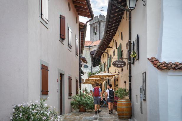 Ein Paar geht eine Gasse mit einem Restaurant namens „Marica“ entlang.