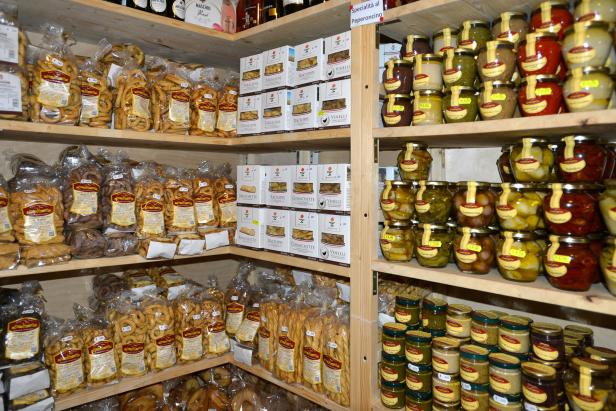 Regale in einem Feinkostladen gefüllt mit Taralli, Bruschetta und eingelegtem Gemüse.