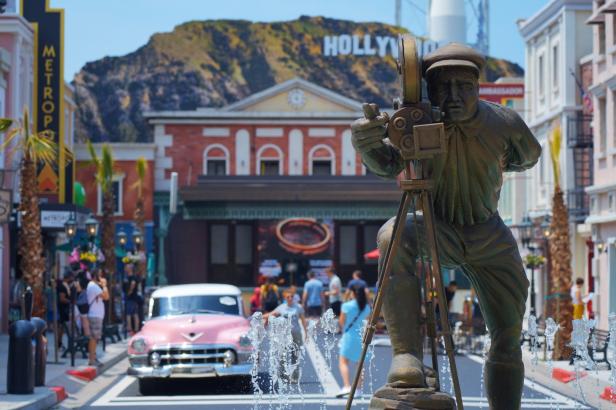 Eine Statue eines Kameramanns vor einer Kulisse des Hollywood-Zeichens.