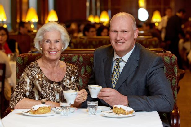 Ein älteres Paar sitzt im Café Landtmann und genießt Kaffee und Apfelstrudel.