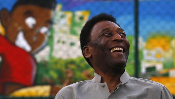 Pelé lächelt vor einem bunten Wandgemälde.