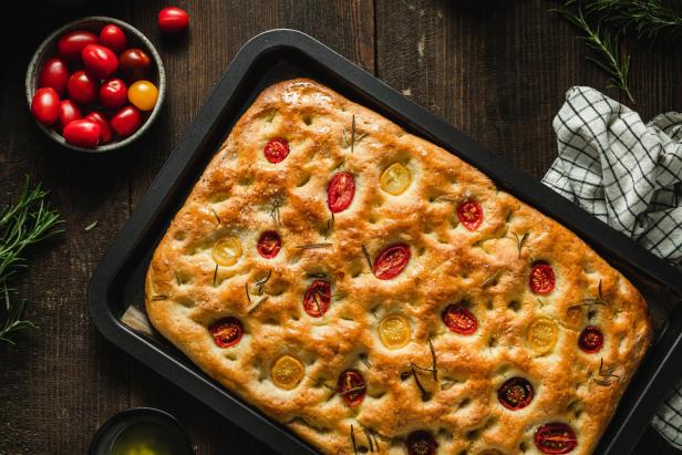 Italienisches Focaccia-Brot auf einem Blech mit Tomaten.
