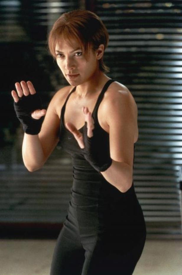 Jennifer Lopez in Sportkleidung und Bandagen an den Händen in einer Kampfpose.