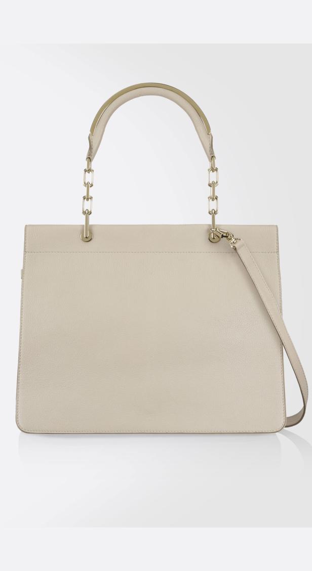 Eine beigefarbene Handtasche mit goldenen Ketten und einem Schulterriemen.