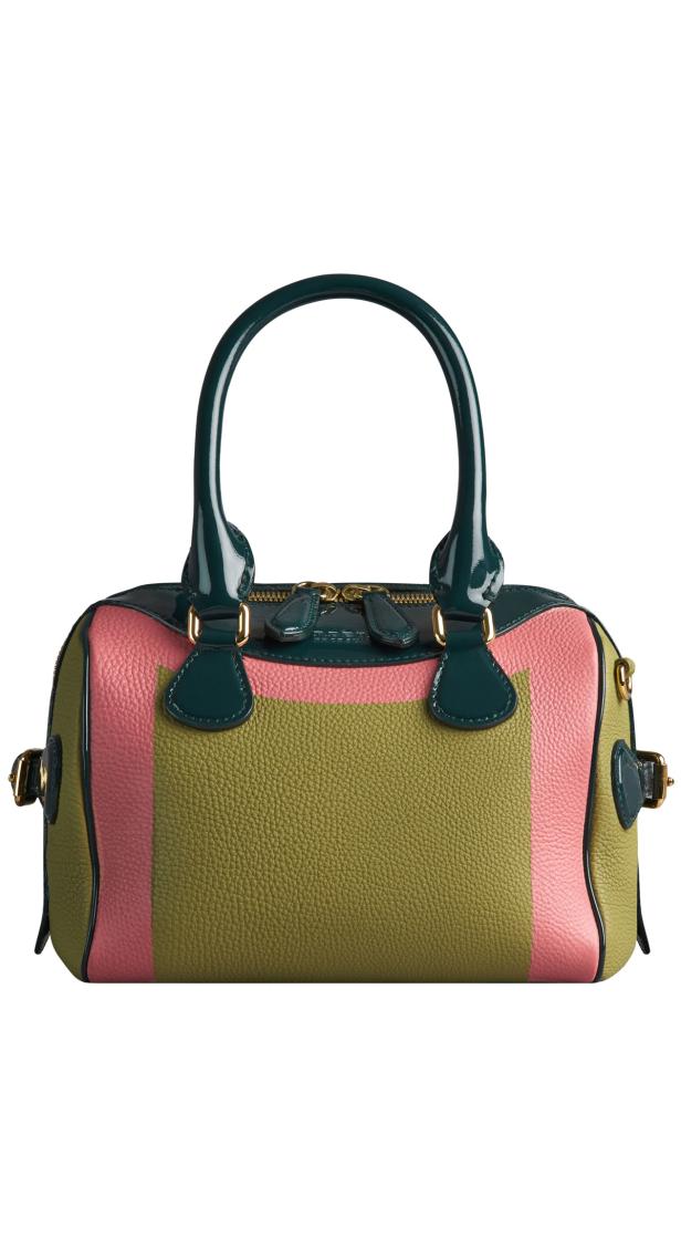 Eine Handtasche in Grün-, Rosa- und Olivtönen mit glänzenden, dunkelgrünen Henkeln.