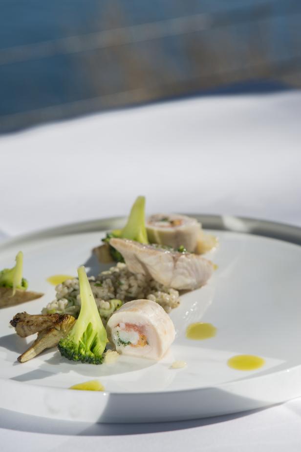 Ein Teller mit Geflügelrouladen, Perlgraupen und Gemüse garniert.