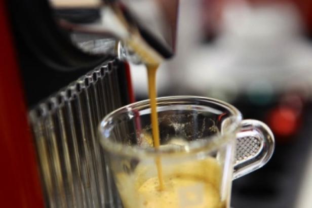 Espresso läuft in eine Tasse.