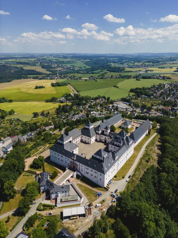 Luftaufnahme von Schloss Rochlitz in Sachsen vor ländlicher Kulisse.