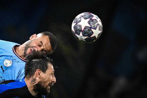 Zwei Fußballspieler kämpfen um einen Ball in der Luft.