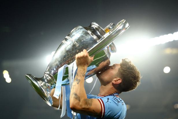 Ein Fußballspieler von Manchester City küsst die Champions-League-Trophäe.