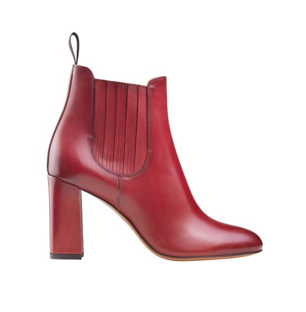 Ein roter Lederstiefelette mit Absatz vor einem weißen Hintergrund.