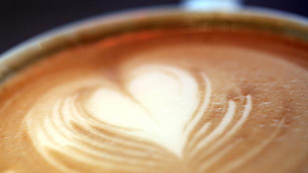 Nahaufnahme eines Cappuccinos mit Herzmuster.