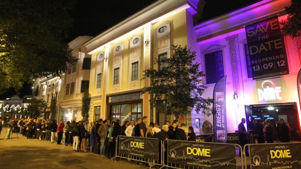 Eine lange Schlange von Menschen wartet vor dem Prater Dome in Wien.