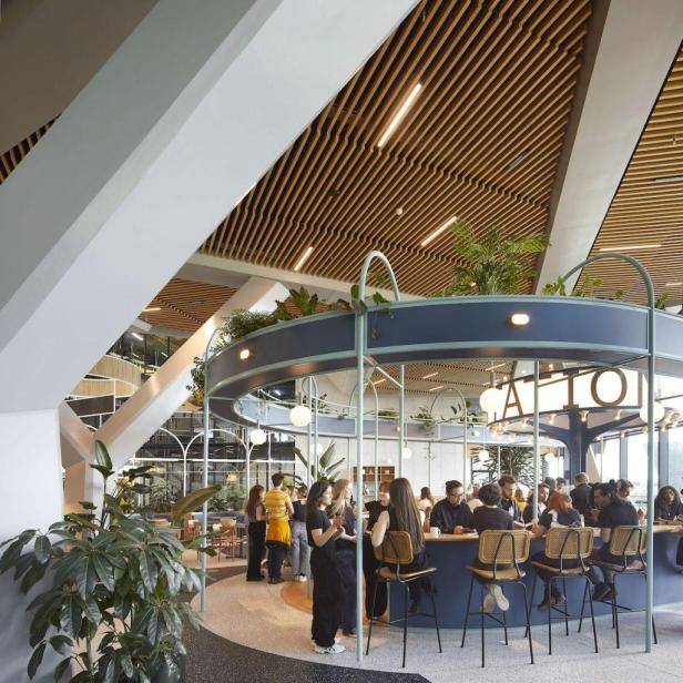 Menschen sitzen und stehen an einer Bar in einem modernen Bürogebäude.