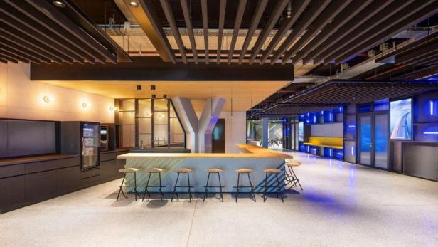 Eine moderne Büroküche mit einer langen Theke und Barhockern.