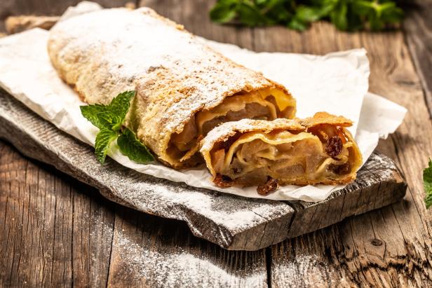 Apfelstrudel auf einem Brett und mit Staubzucker überdeckt
