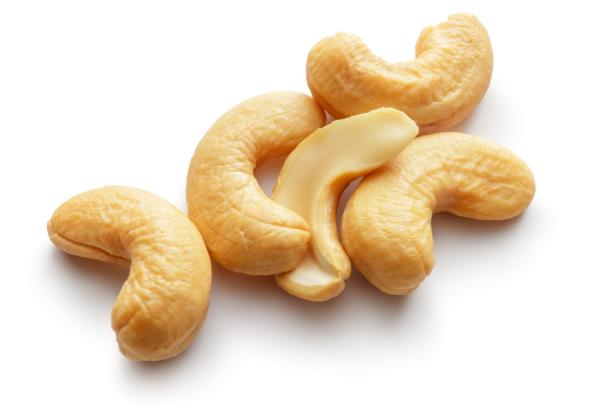 Mehrere Cashewnüsse liegen auf einem weißen Hintergrund.