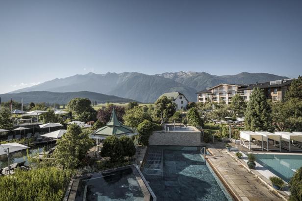 Das Alpenresort Schwarz in Tirol mit Pools und Blick auf die Berge.