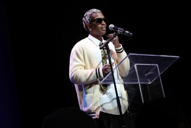 A$AP Rocky bei der 16th Harlem's Fashion Row auf der Bühne, trägt Haarspangen und passende Ohrringe.