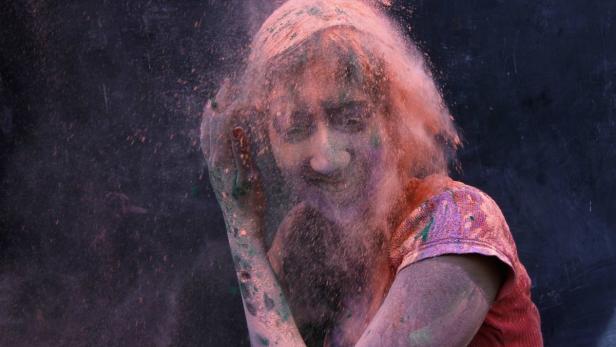 Eine Frau ist mit Farbpulver bedeckt.
