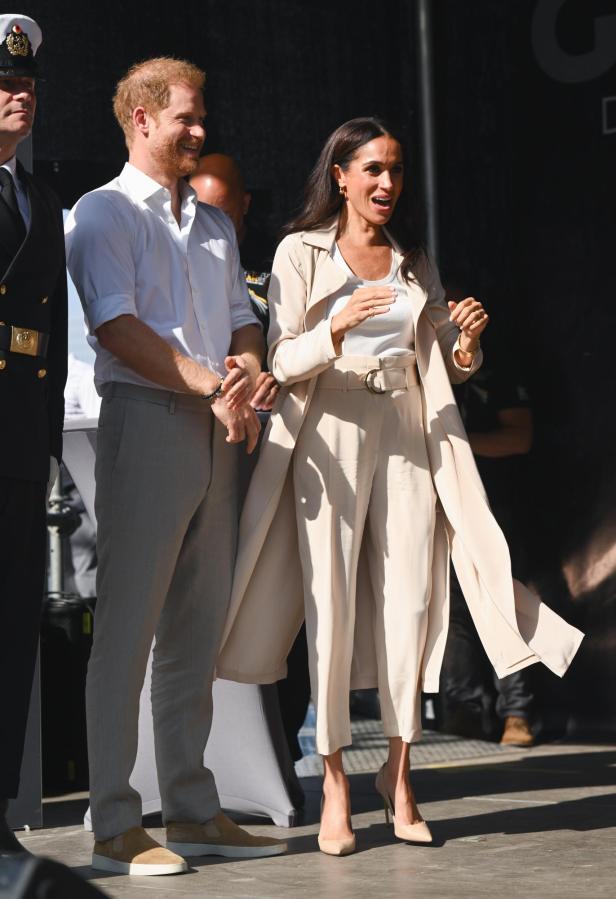 Meghan Markle und Prinz Harry stehen zusammen auf einer Bühne.