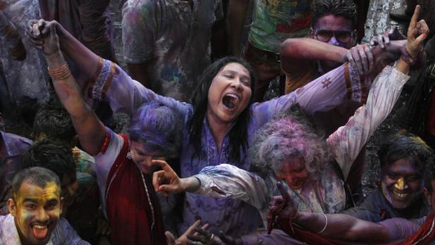 Menschen feiern das Holi-Fest mit bunten Farben und ausgelassener Stimmung.
