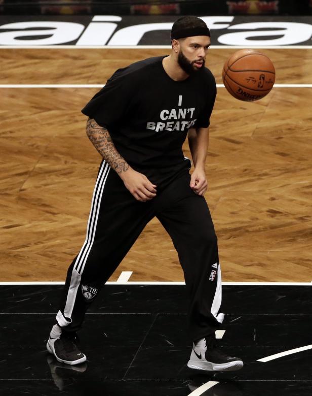 Ein Basketballspieler der Brooklyn Nets mit einem T-Shirt mit der Aufschrift „I CAN'T BREATHE“ wirft einen Ball.