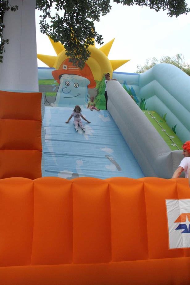 Ein Mädchen rutscht eine aufblasbare Wasserrutsche hinunter.