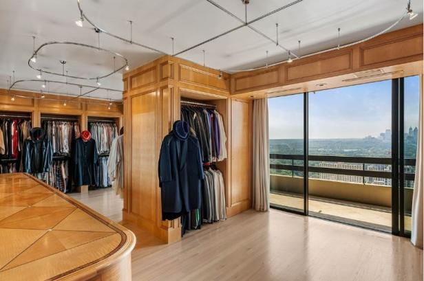 Ein begehbarer Kleiderschrank mit Holzvertäfelung und Blick auf eine Stadt.
