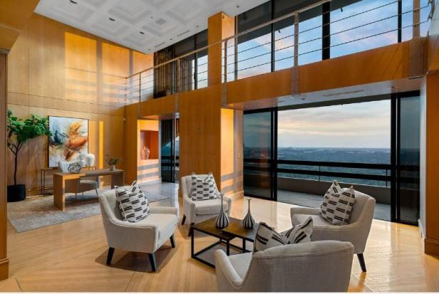 Ein luxuriöses Wohnzimmer mit Sesseln und Blick auf die Stadt.