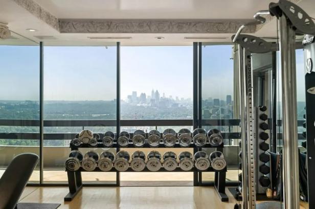 Ein Fitnessraum mit Hanteln und Blick auf die Skyline der Stadt.