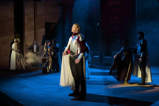 Eine Theaterszene mit Schauspielern in historischen Kostümen auf einer Bühne.