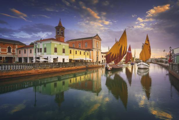 Bunte Häuser und traditionelle Segelboote im Hafen von Cesenatico an der Adria.