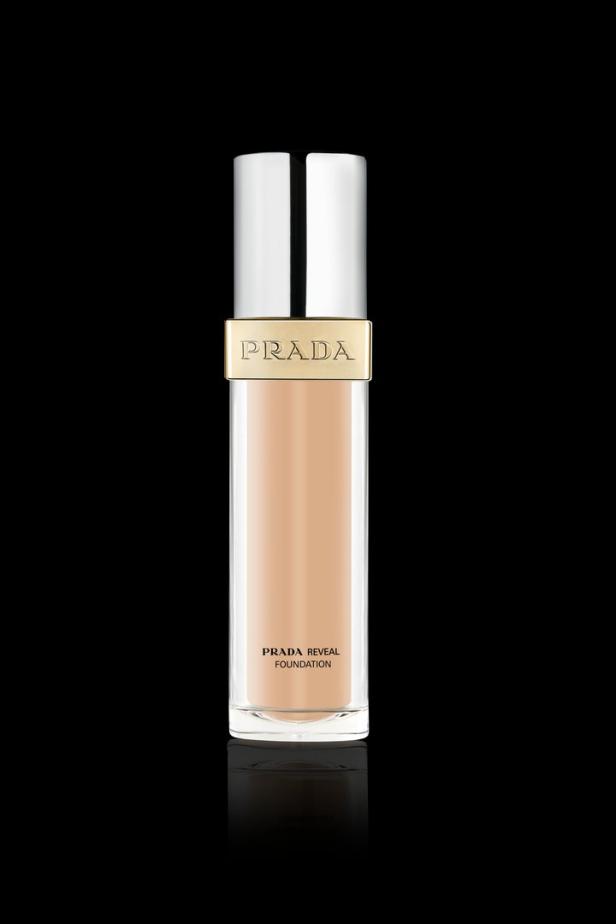 Eine Flasche „Prada Reveal Foundation“ auf schwarzem Hintergrund.