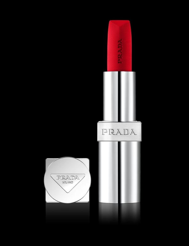 Ein roter Prada-Lippenstift mit silberner Hülle vor schwarzem Hintergrund.