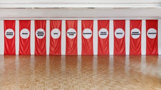 Eine Reihe roter Banner mit den Logos verschiedener Unternehmen, darunter Amazon, IKEA und Nestlé.