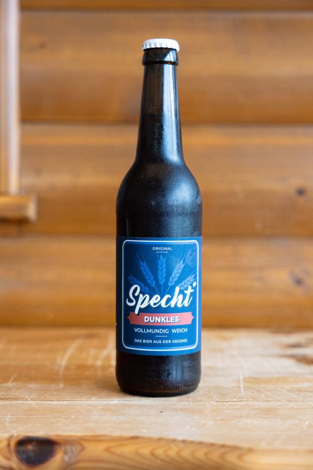 Eine Flasche „Specht Dunkles“ Bier steht auf einem Holztisch.
