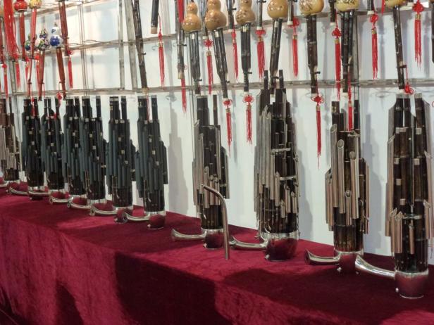 Eine Reihe von Sheng-Instrumenten, traditionelle chinesische Mundorgeln, stehen auf einem roten Tuch.