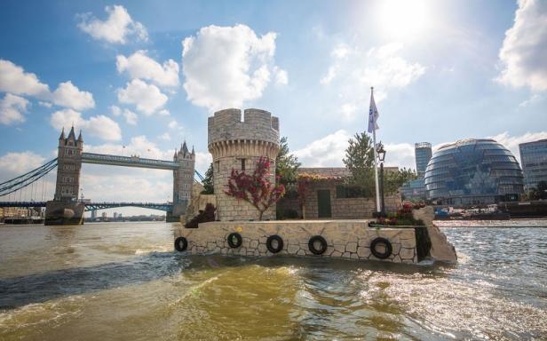 Eine schwimmende Burg auf der Themse mit der Tower Bridge im Hintergrund.