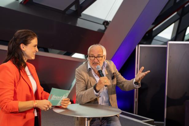 Ein Mann spricht bei einer „Freizeit Live“-Veranstaltung in ein Mikrofon.
