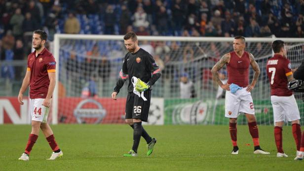 Enttäuschte Fußballspieler des AS Rom stehen nach einem Spiel auf dem Rasen.