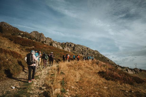Eine Gruppe Wanderer geht einen Pfad auf einem Berg entlang.