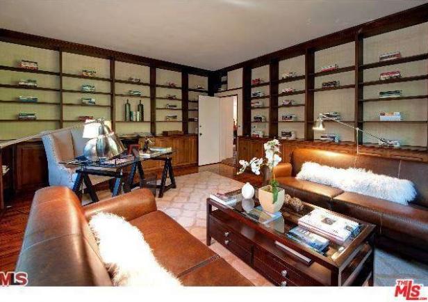 Ein Wohnzimmer mit Bücherregalen, Ledersofas und einem Schreibtisch.