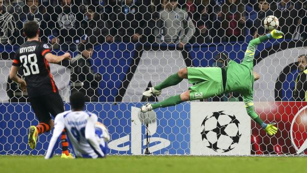 Ein Fußballtorwart in Grün wehrt einen Schuss ab.