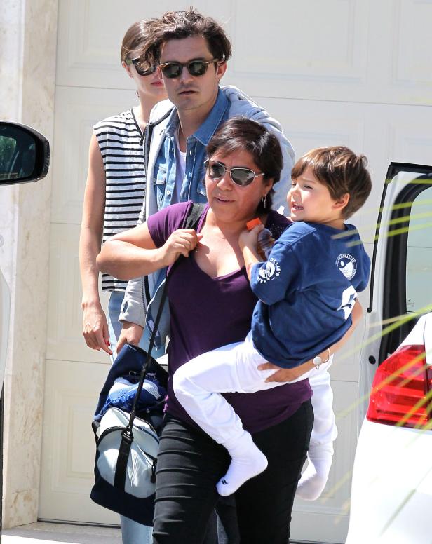 Orlando Bloom mit Familie vor einem Haus.