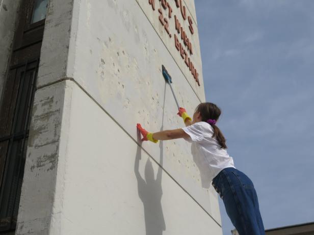 Eine Aktivistin, die das Gebäude mit einer Bürste putzt