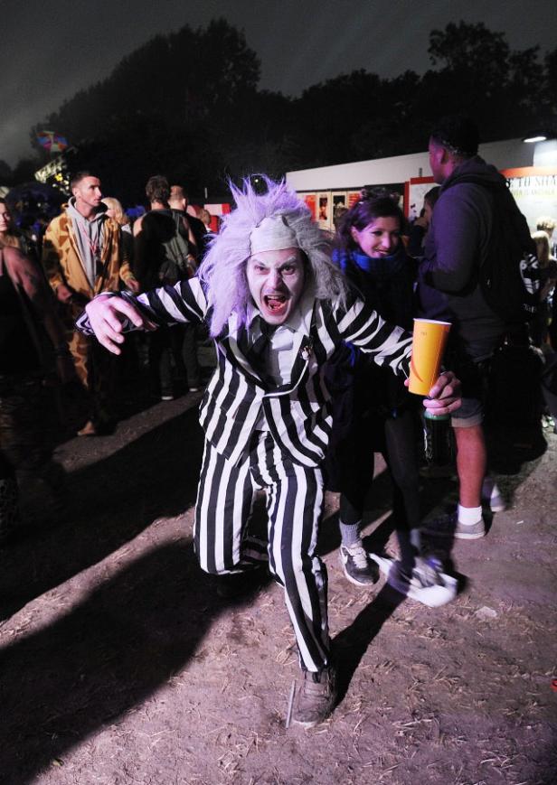 Ein Mann, verkleidet als Beetlejuice, rennt auf einer Veranstaltung auf die Kamera zu.
