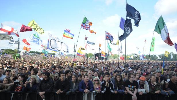 Eine große Menschenmenge mit vielen Flaggen bei einer Open-Air-Veranstaltung.
