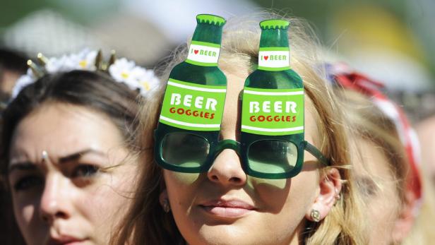 Eine Frau trägt eine „Beer Goggles“-Brille in Form von Bierflaschen.